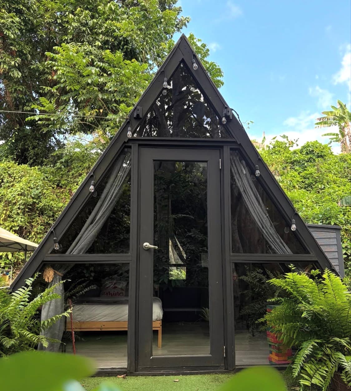A-frame bush cabin nestled among green trees